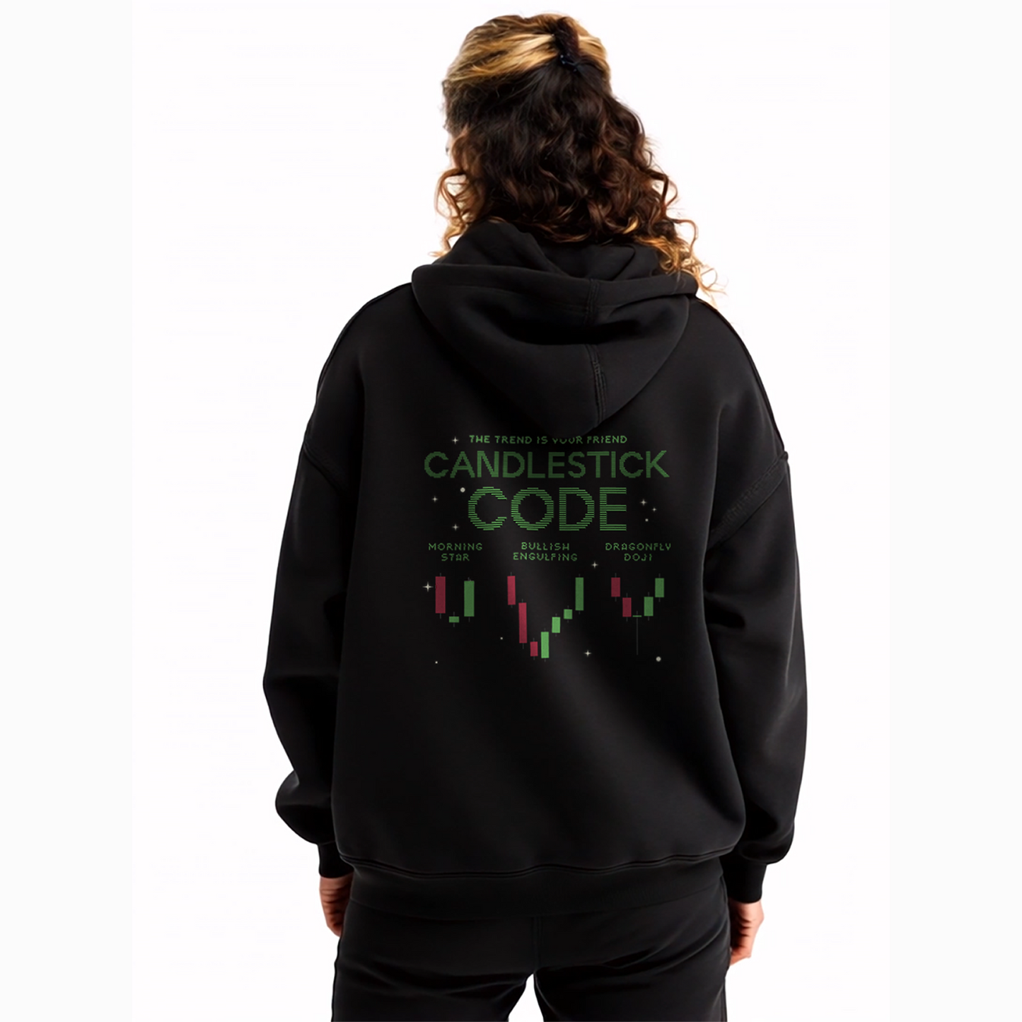 Woman wearing oversized black hoodie with small green chest text that reads “Ride the Wave,” styled with black joggers