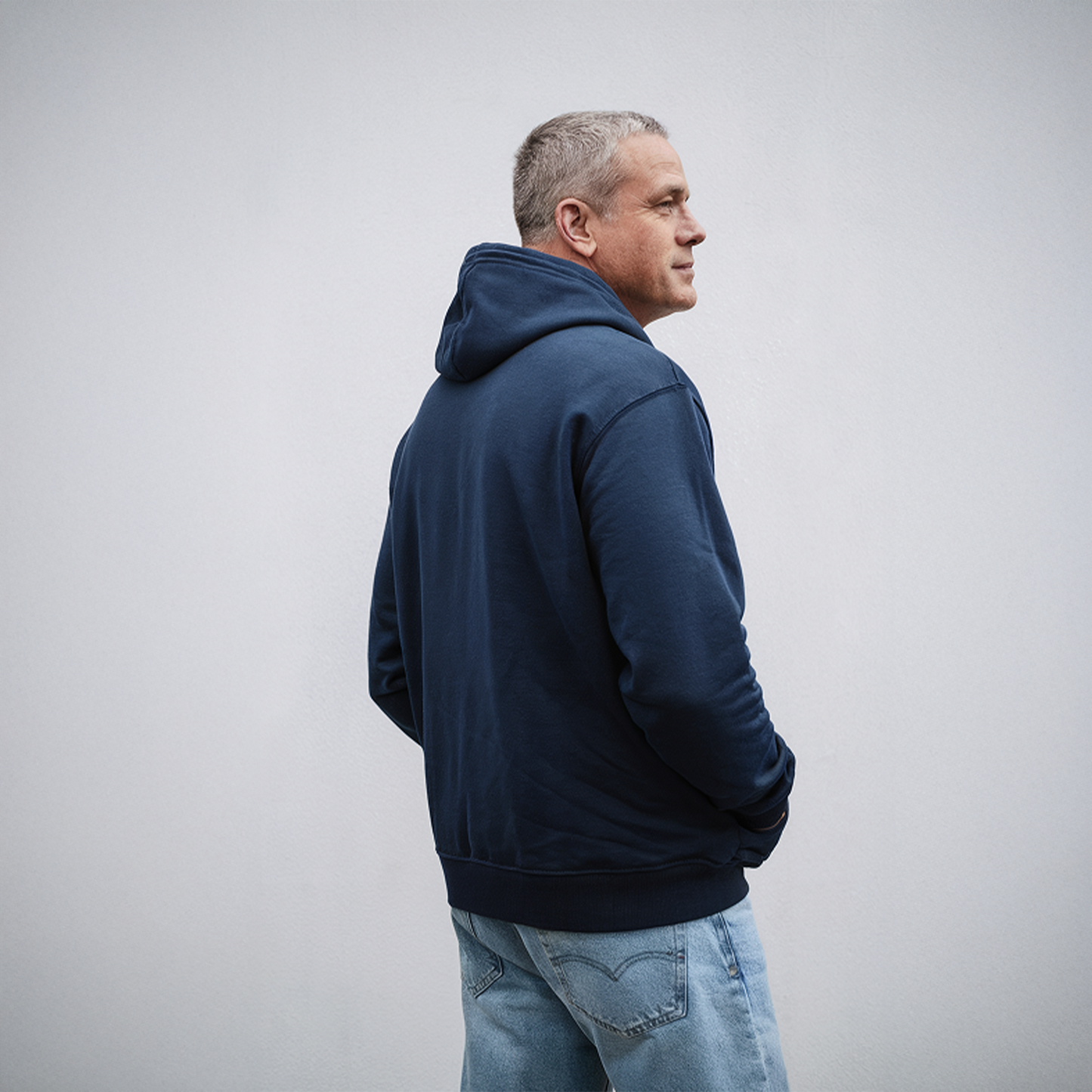 Man wearing navy blue hoodie with bold text: “Built Tough for Market Dips & Toddler Tantrums,” featuring purple financial and parenting-themed icons