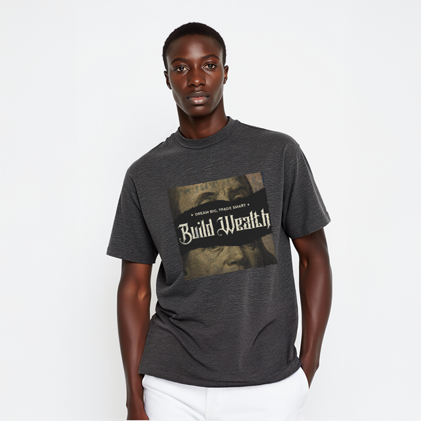 Man wearing dark gray t-shirt with vintage-style “Build Wealth” graphic and the phrase “Dream Big, Trade Smart,” styled with white pants