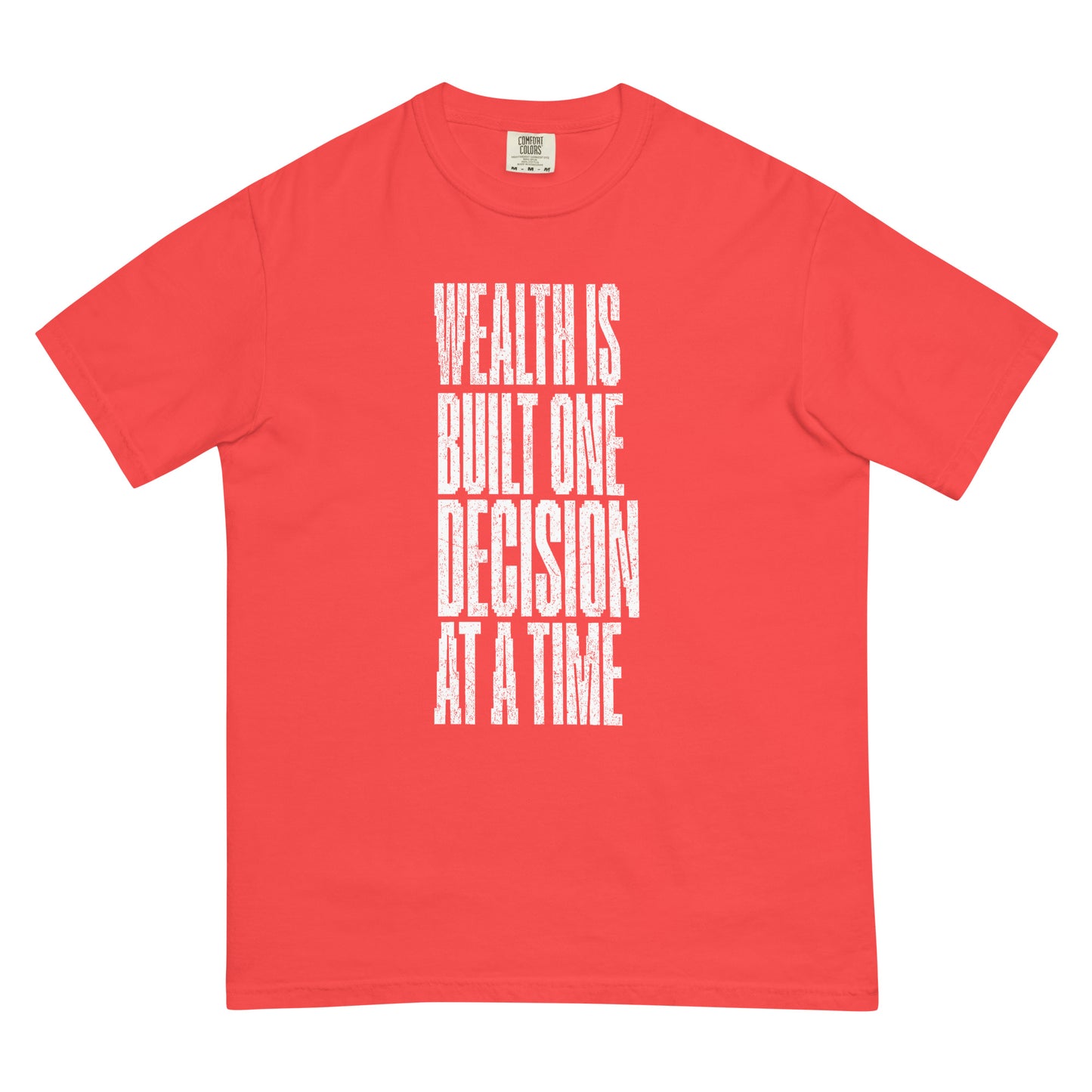 Man wearing red graphic t-shirt with bold vertical white text that reads “Wealth Is Built One Decision At A Time,” paired with jeans