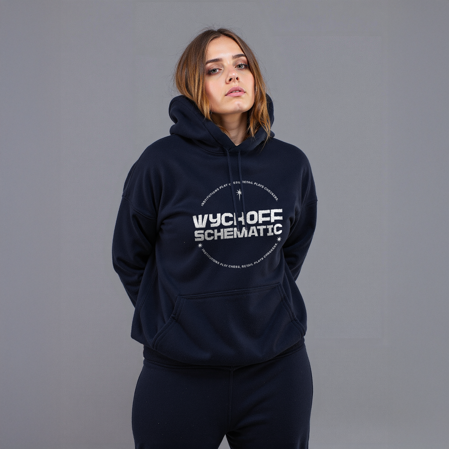 Woman wearing navy “Wyckoff Schematic” hoodie with circular crypto trading graphic, styled in matching sweatpants against gray background