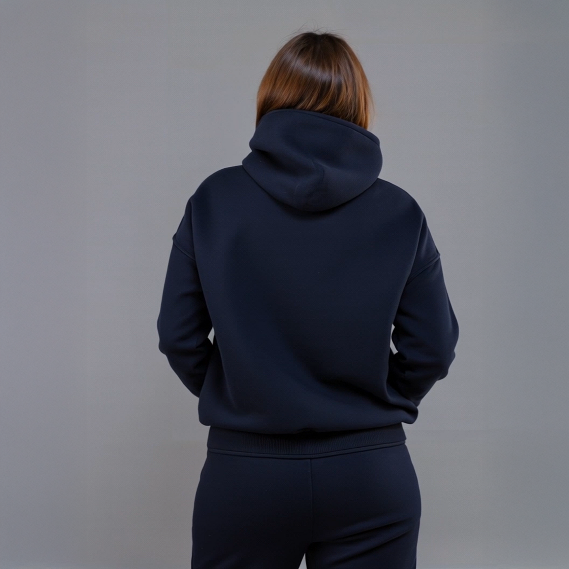 Woman wearing navy “Wyckoff Schematic” hoodie with circular crypto trading graphic, styled in matching sweatpants against gray background